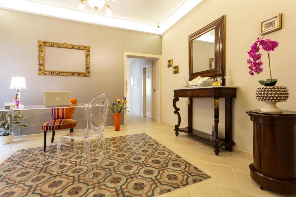 a living room with a table and a mirror at Maecò Ortigia B&B - Deluxe Rooms & Suites in Syracuse