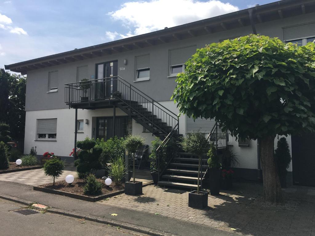 un edificio con una escalera y un árbol delante de él en Hanne's Gästestudio en Osann-Monzel