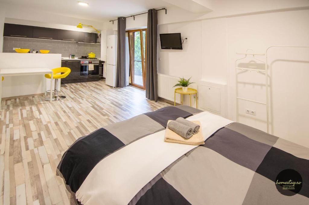 a bedroom with a large bed and a kitchen at Homestay Otopeni in Otopeni