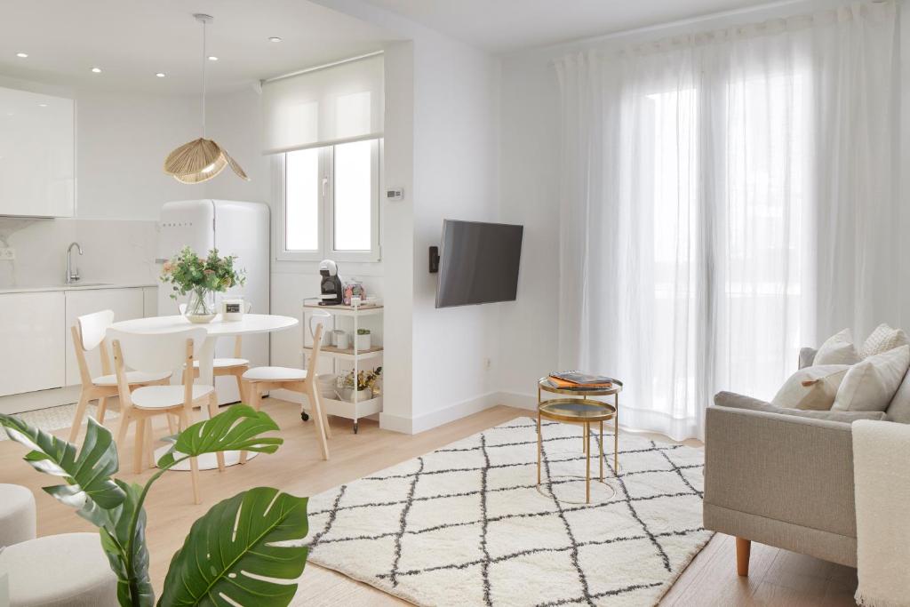 a white living room with a table and a couch at Moneo by FeelFree Rentals in San Sebastián