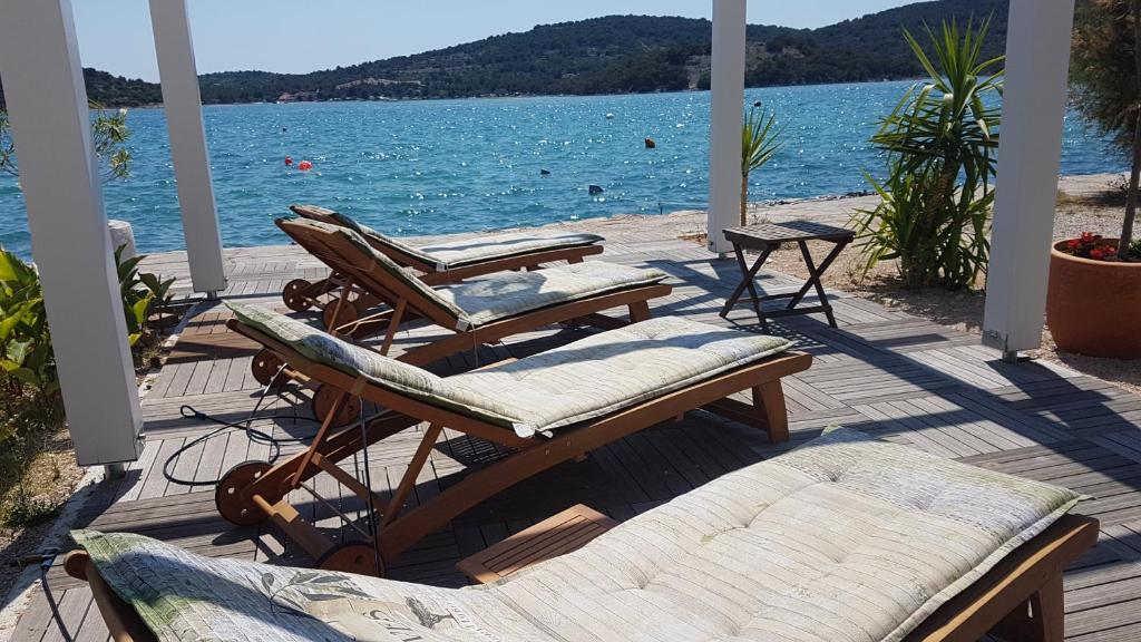 a porch with chairs and a view of the water at Apartments Antonio in Tisno