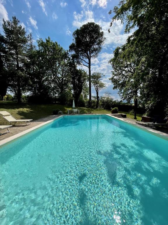 a swimming pool with blue water in a yard at Villa Resta & Dependance in Castel San Pietro Terme