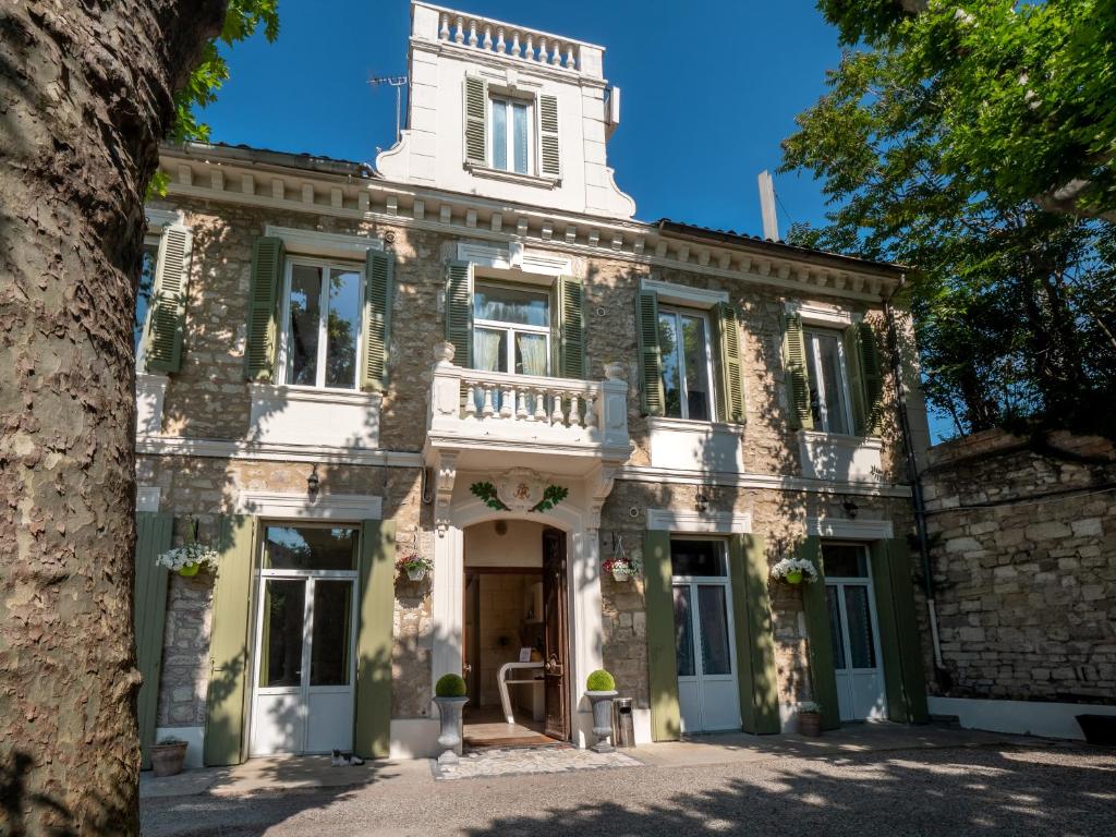 Casa de piedra antigua con balcón en la parte delantera en Altera Roma Hôtel, en Aviñón