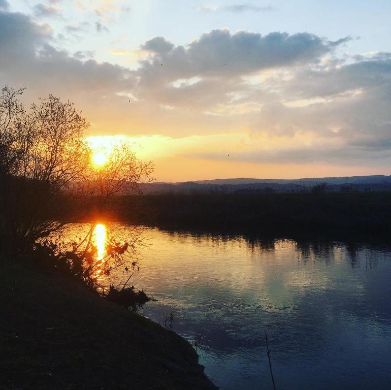 een zonsondergang boven een rivier met zonsondergang bij Ferienwohnungen Lausbuben & Zicken - im grünen Herzen Deutschlands in Herleshausen