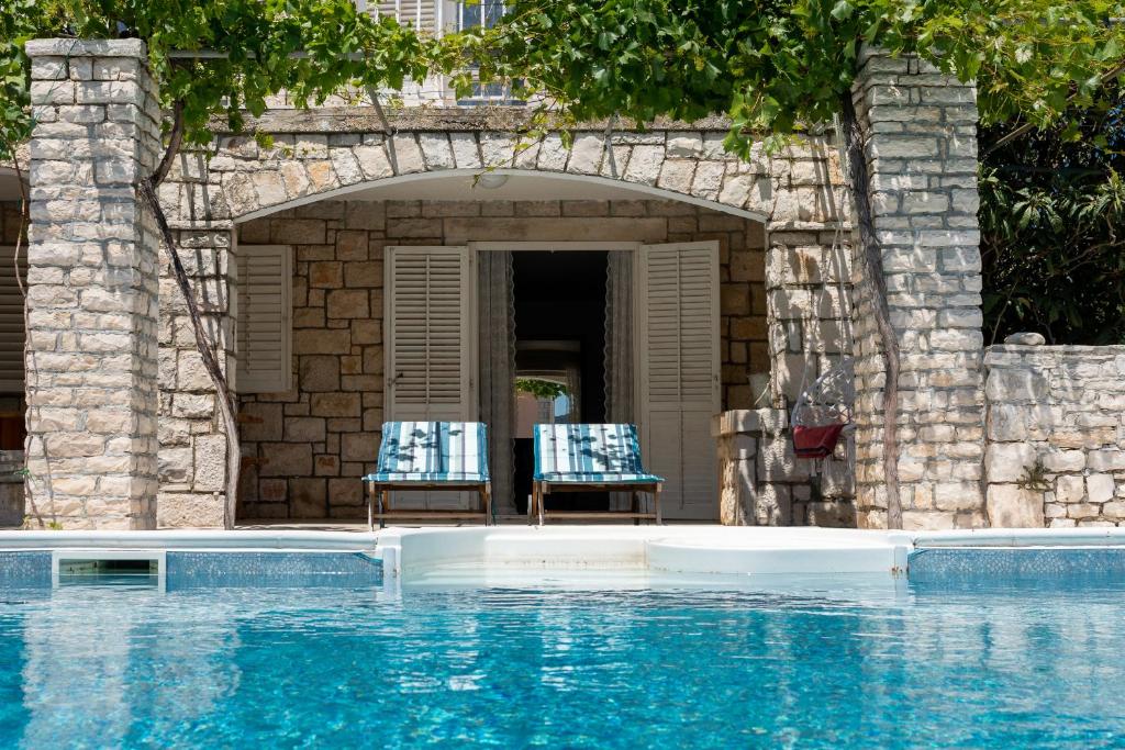 two chairs sitting next to a swimming pool at Villa Gradina 01 in Vela Luka