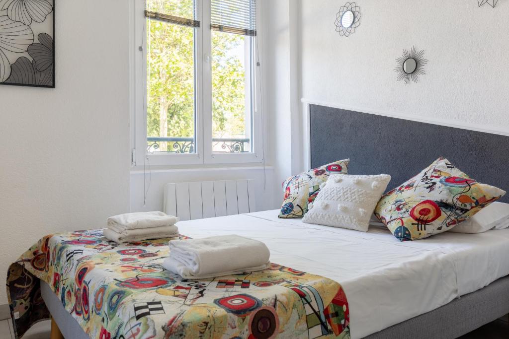 een bed met handdoeken bovenop in een slaapkamer bij Travel Homes - L'Alsacien, près de la ville in Mulhouse