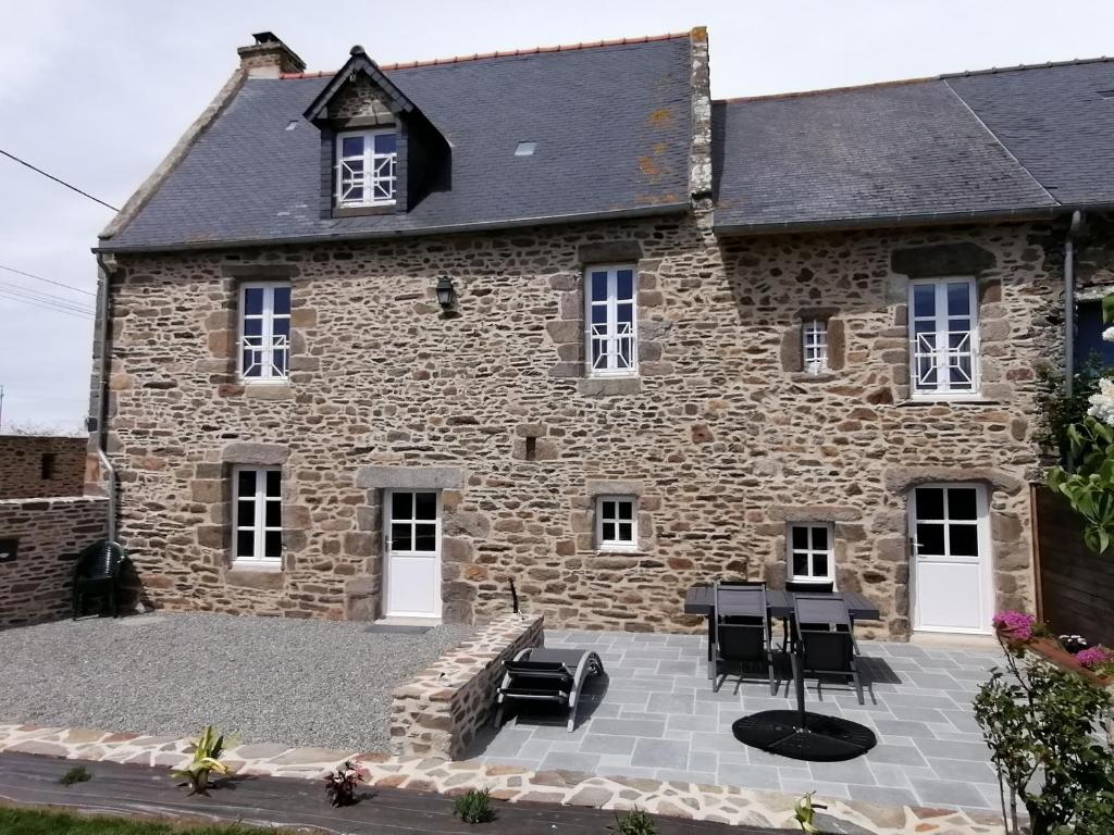 een stenen huis met een patio ervoor bij L'Tas De Cailloux in Cancale