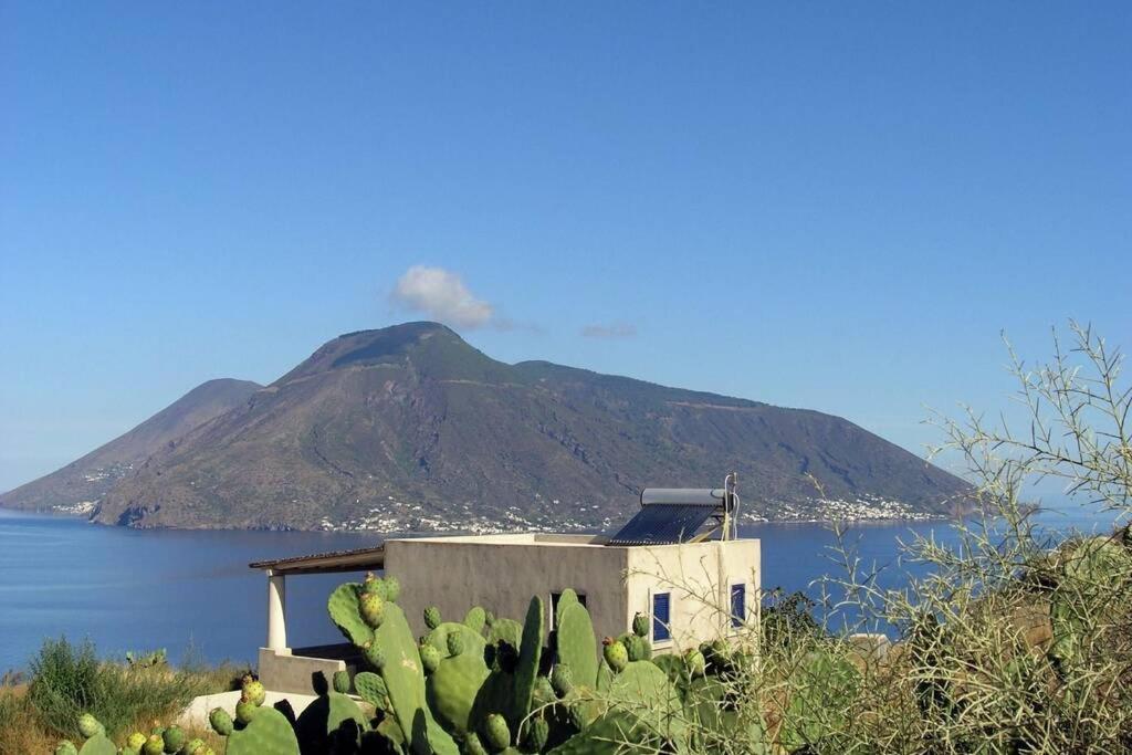 uma montanha ao fundo com uma casa e cactos em La casa blu exclusive em Quattro Pani