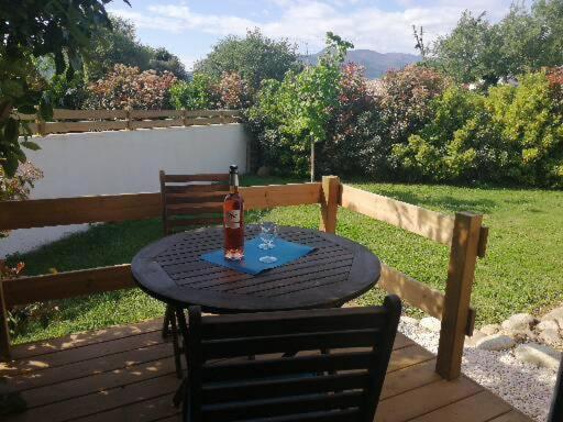 een tafel met een fles wijn op een terras bij Appartement de vacances à la campagne in Saint-Jean-Pla-de-Corts