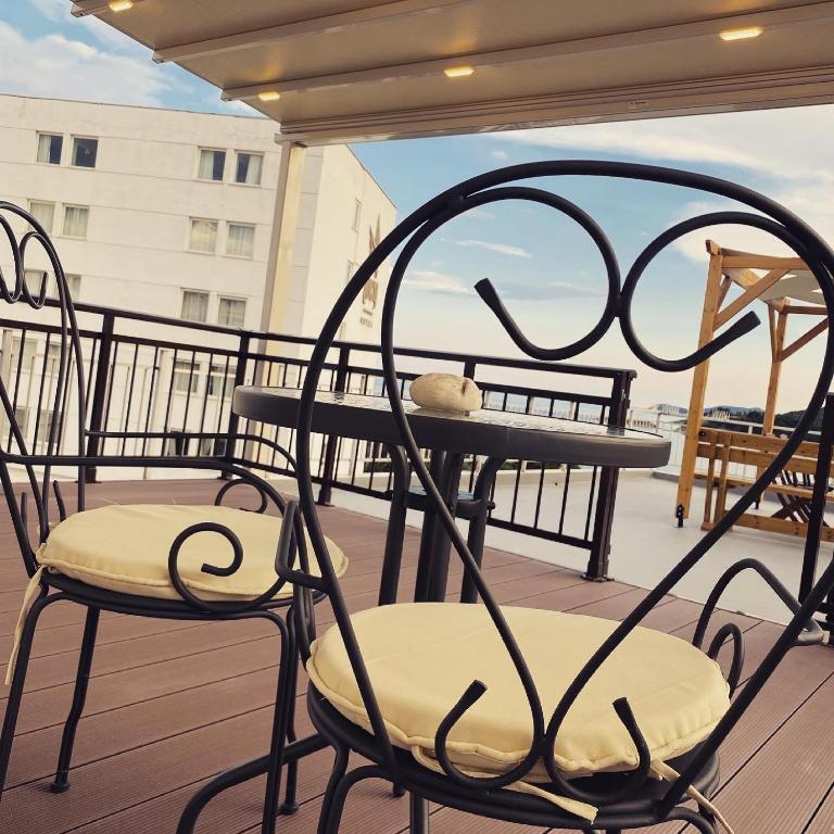 a pair of chairs and a table on a balcony at Overwave Apartment in Kavála