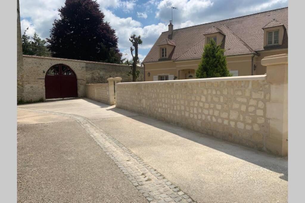 - un bâtiment avec un portail et un mur en pierre dans l'établissement Studio indépendant dans maison neuve, à Senlis
