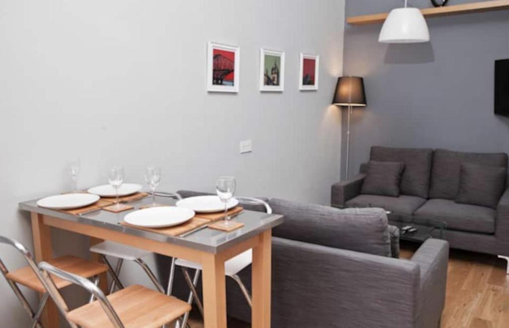 - un salon avec une table et un canapé dans l'établissement Royal Mile Apartment, à Édimbourg