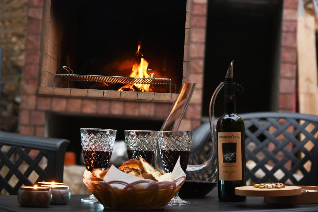 a table with glasses and a bottle of wine and a fireplace at Casa Isabella Light Blue Intero Appartamento in Sorso