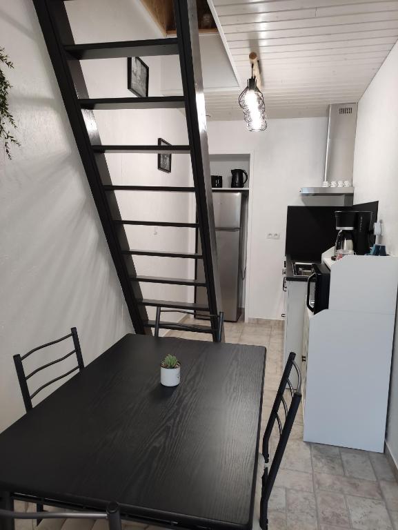 a table and chairs in a room with a kitchen at L'ENTRE-TEMPS in Chambretaud