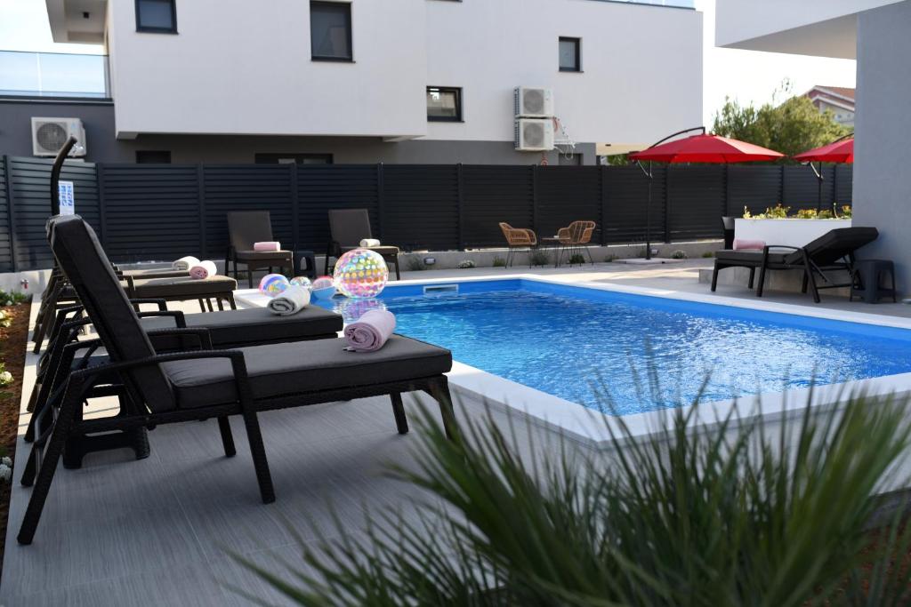 une terrasse avec une table et une piscine dans l'établissement B1villa, à Srima