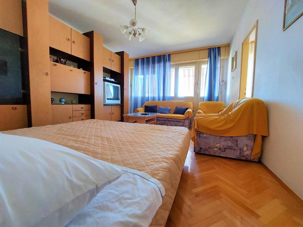 1 dormitorio con 1 cama y 2 sillas en Apartman Ninsky en Primošten