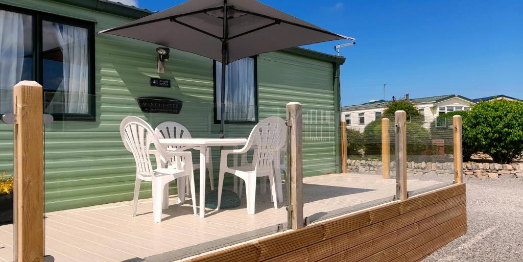 a deck with a table and chairs and an umbrella at Ruan's Roost in Carlisle