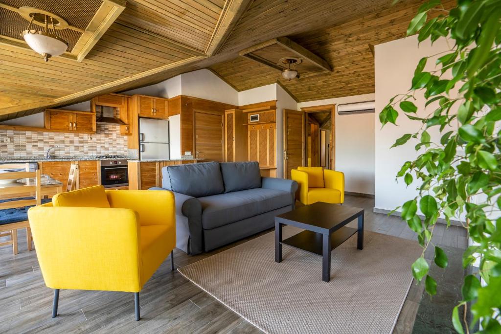 XOX Apart Hotel في أكياكا: غرفة معيشة مع كراسي صفراء وأريكة