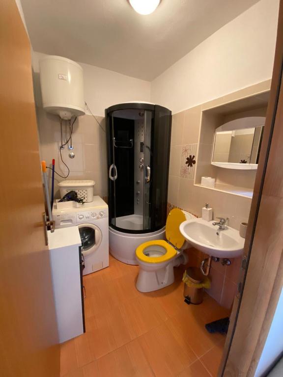 W łazience znajduje się toaleta, umywalka i pralka. w obiekcie Varga apartment w mieście Opatija