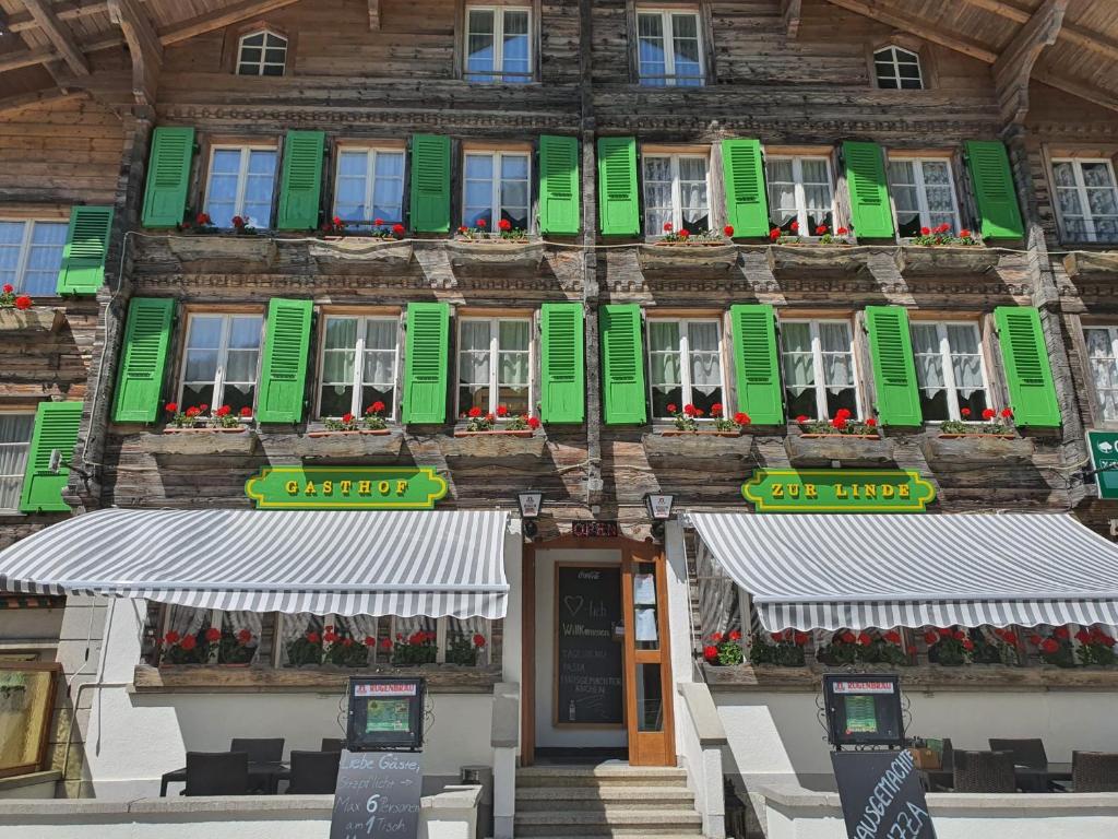 a building with green and white shutters on it at Hotel-Restaurant-Linde in Gundlischwand