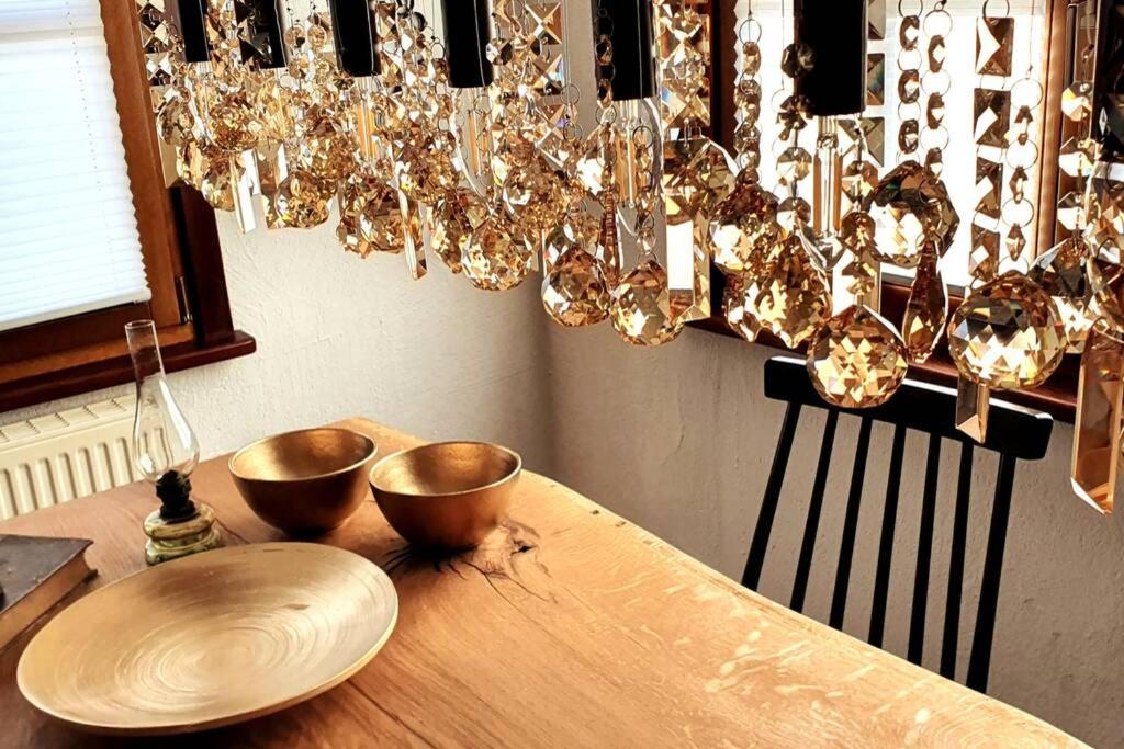 a wooden table with two bowls and a chandelier at Schatzkästchen treasure chest stylish living on the Bodensee in Öhningen