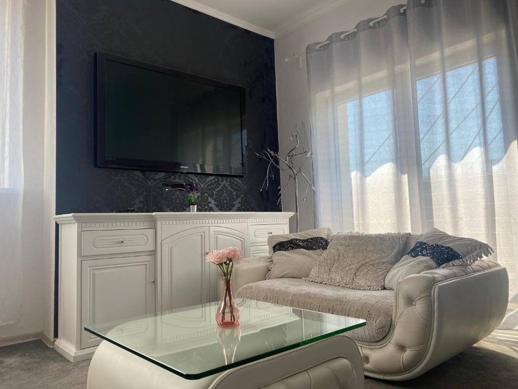 uma sala de estar com um sofá e uma mesa de vidro em AtmosferA em Bydgoszcz