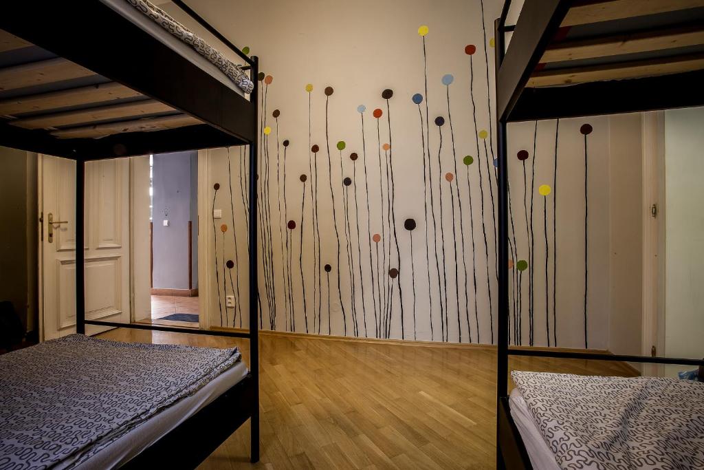 a room with two bunk beds and a wall with pins at Ahoy! Hostel in Prague