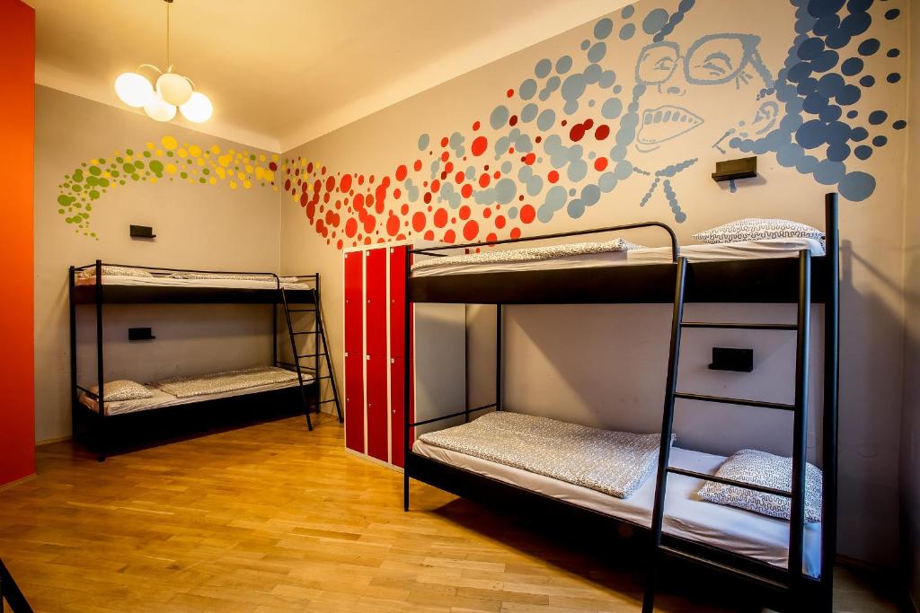 a room with three bunk beds and a wall at Ahoy! Hostel in Prague