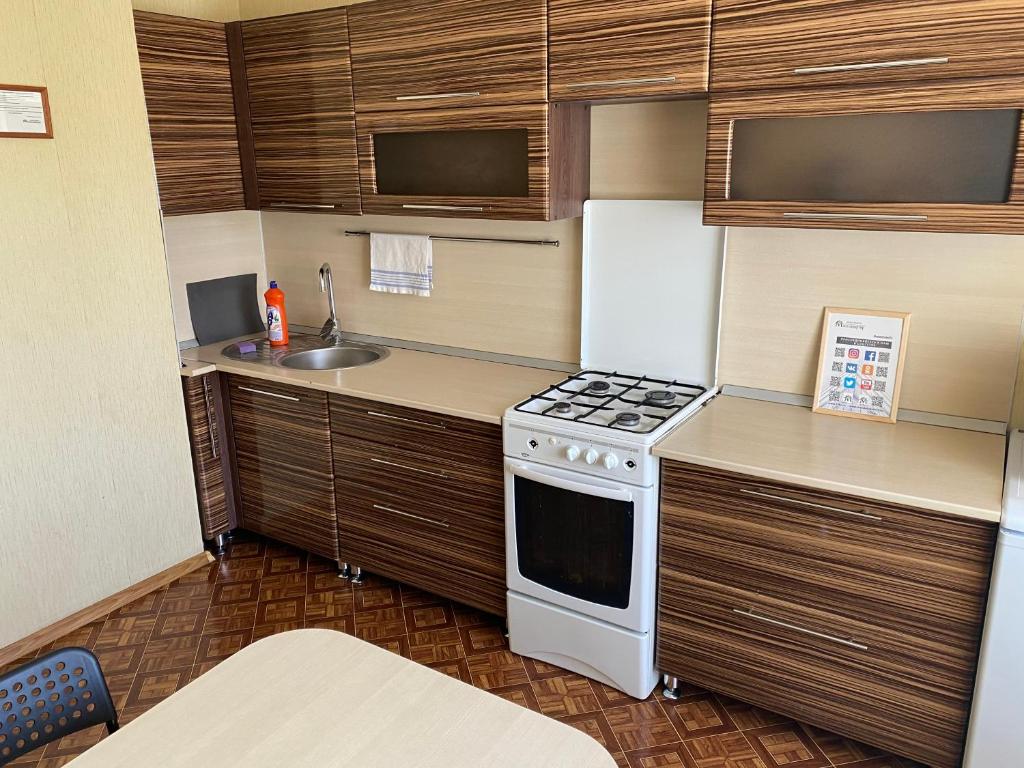 a small kitchen with a stove and a sink at Apartments on Otradnaya 79 in Ulyanovsk