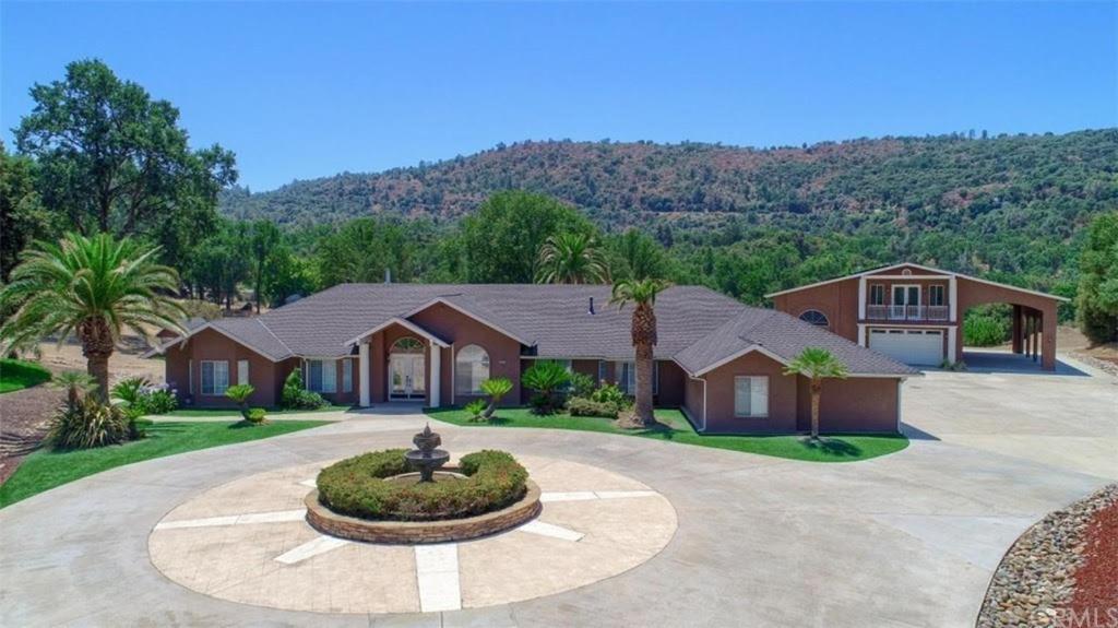 a house with a fountain in the middle of a driveway at Private mountain retreat with pool and mini-golf in Oakhurst