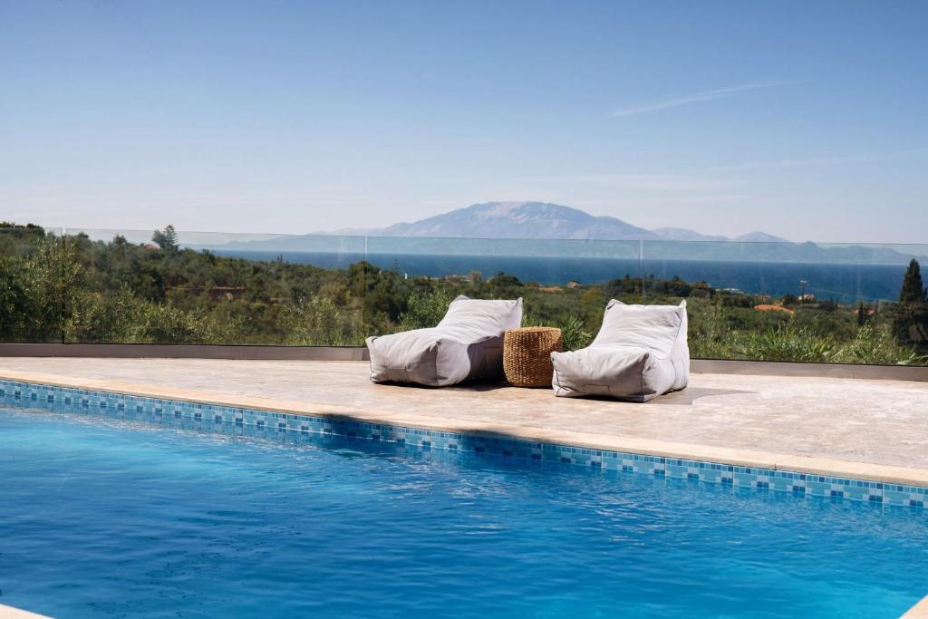 Villa Venia في تراغاكي: وسادتين جالستين بجوار حمام سباحة