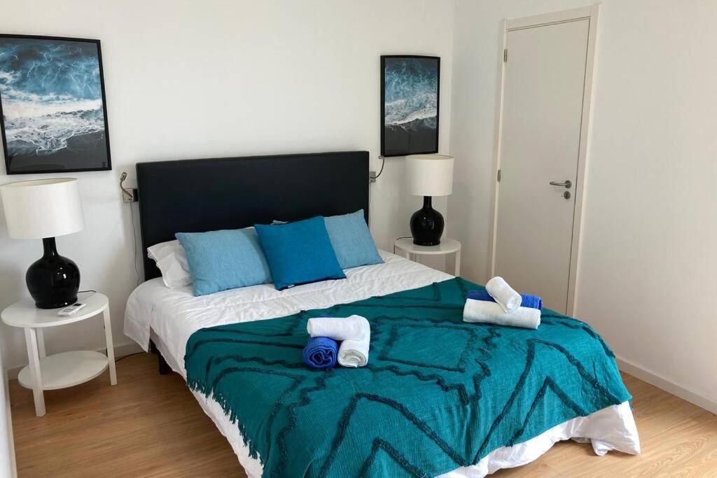 a bedroom with a bed with two towels on it at Azorean Flats V Heart of Ponta Delgada - Centro in Ponta Delgada