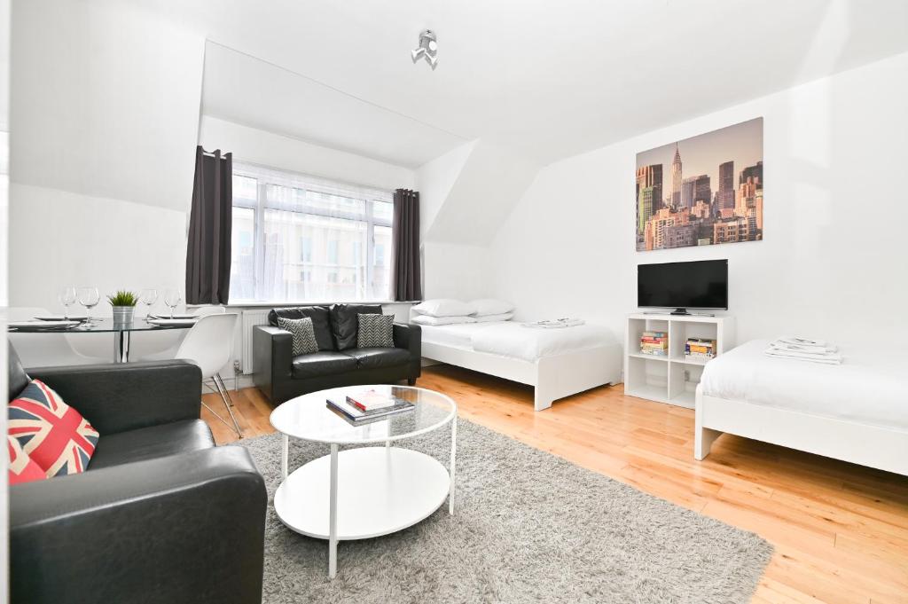 a living room with a couch and a table at Soho Apartment, Theatres & Old Compton Street in London