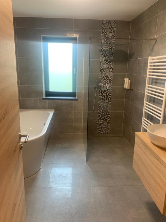a bathroom with a shower and a tub and a sink at SD-Apartment in Spielberg