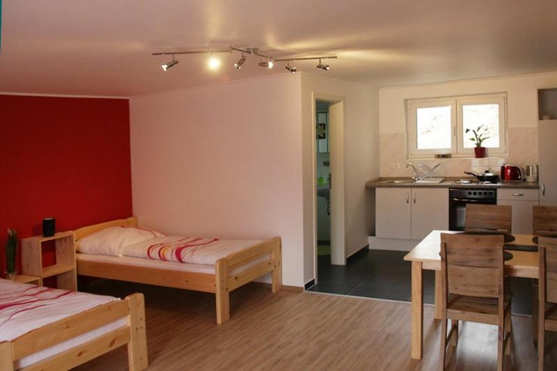 a bedroom with a bed and a table and a kitchen at Gästehaus Silvia in Freigericht