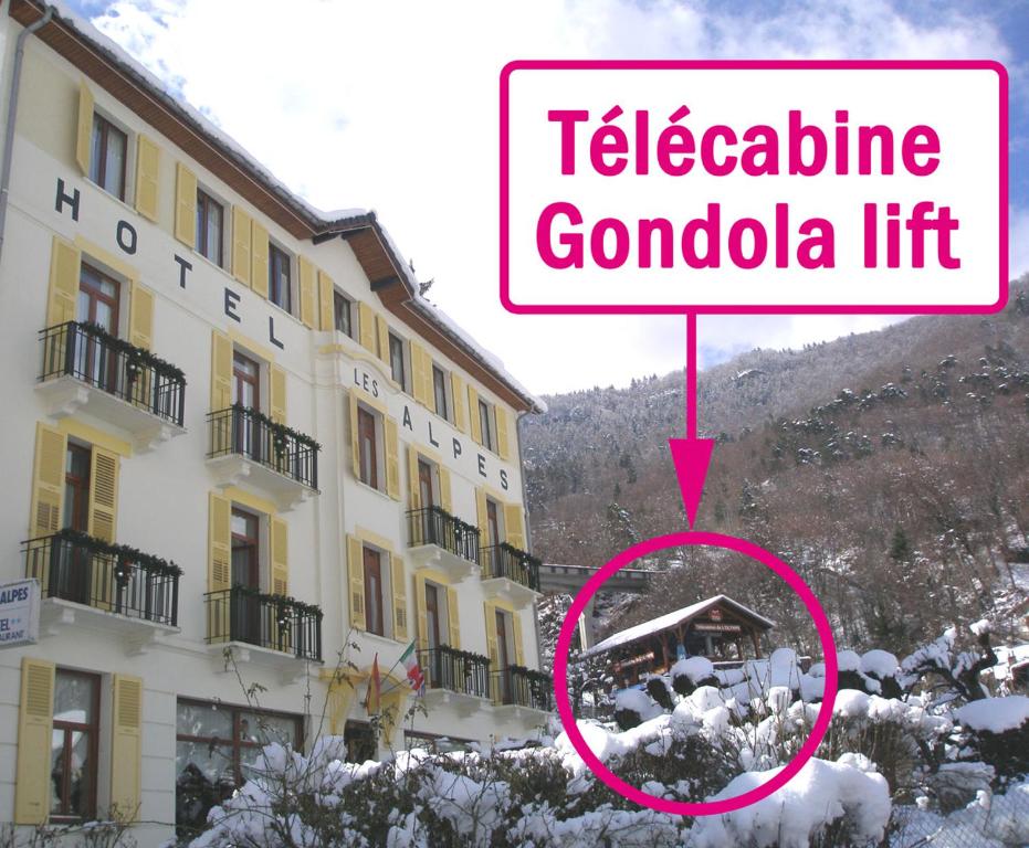 un cartello che legge la cabinovia di fronte a un edificio di Hotel des Alpes a Brides-les-Bains