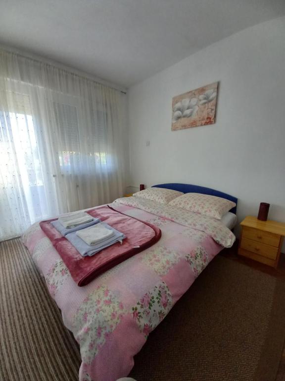 a bedroom with a bed with a pink blanket on it at House Veljko in Vrhovine