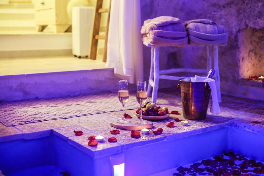a table with two wine glasses and a basket of fruit at La Suite del Marchese in Laterza