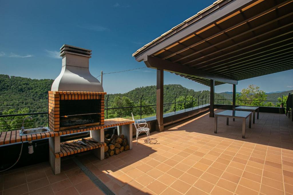 a patio with a fireplace and a picnic table on a deck at Castellpalom in Ripoll