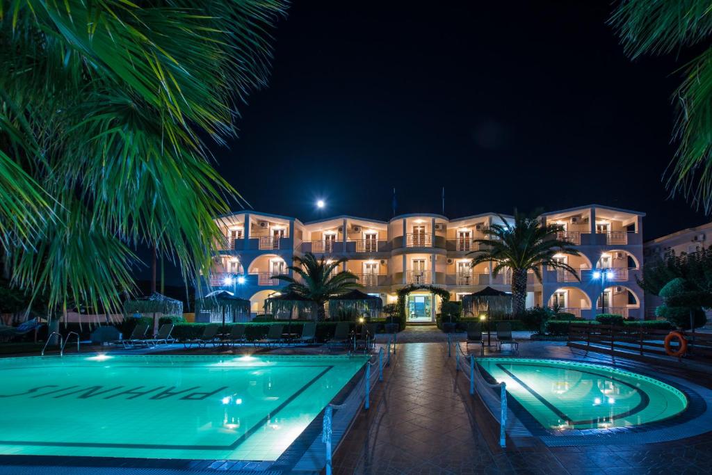 a resort with two pools and a building at night at PAHNIS studios in Alikanas
