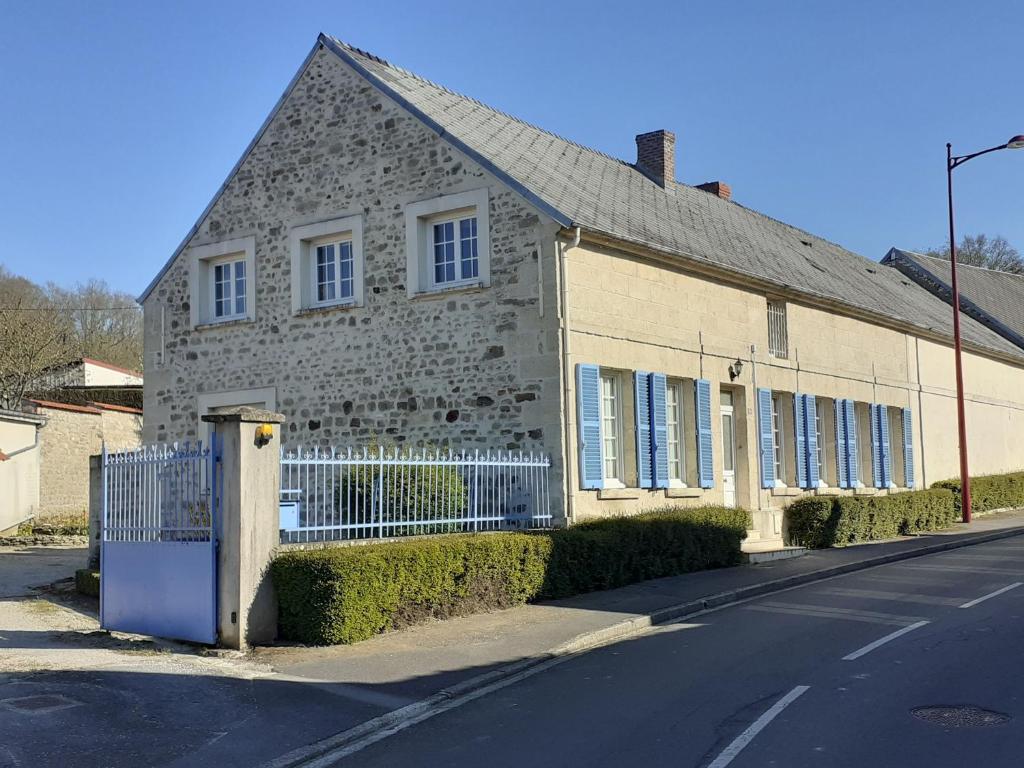 Coucy-lès-Eppes的住宿－Gîte de l'abeille，街道边有围栏的砖砌建筑