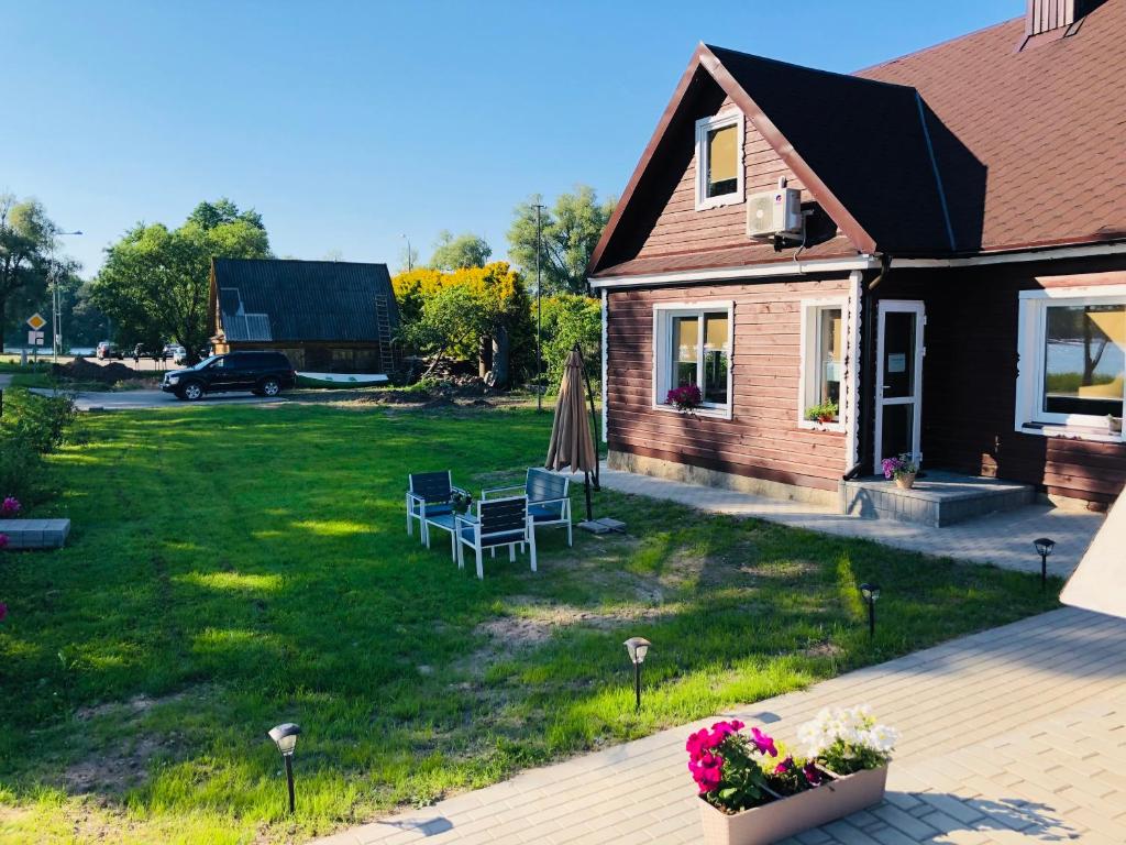 een huis met een tuin met een tafel en stoelen bij Ežerų glėby in Zarasai