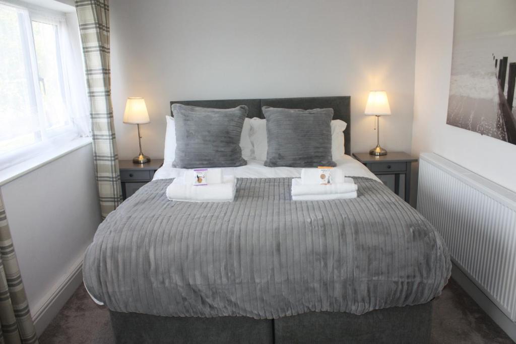 a bedroom with a large bed with two towels on it at Heathmere -NEC, Airport, HS2, Resorts World, Workcation - Spacious quiet apartment in Birmingham