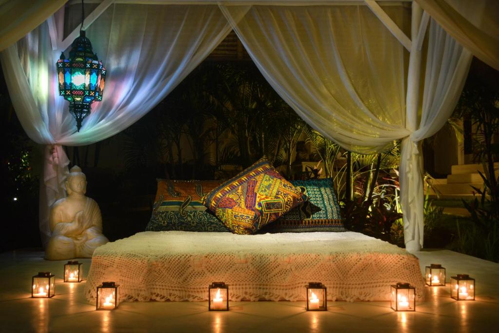 a bedroom with a bed with candles and a chandelier at Sal Secret Spot in Uluwatu
