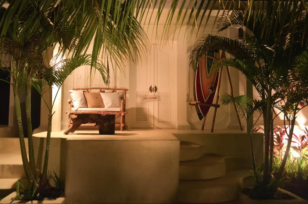 a living room with a couch and palm trees at Sal Secret Spot in Uluwatu