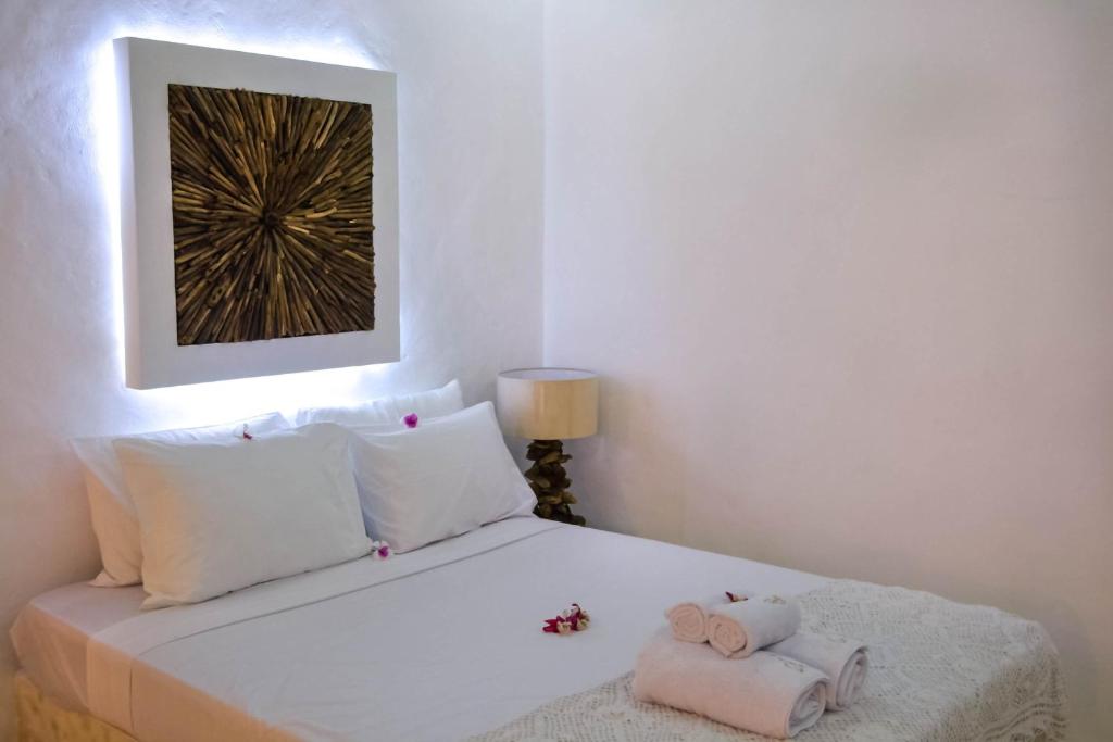 a white bedroom with a bed with towels on it at Sal Secret Spot in Uluwatu