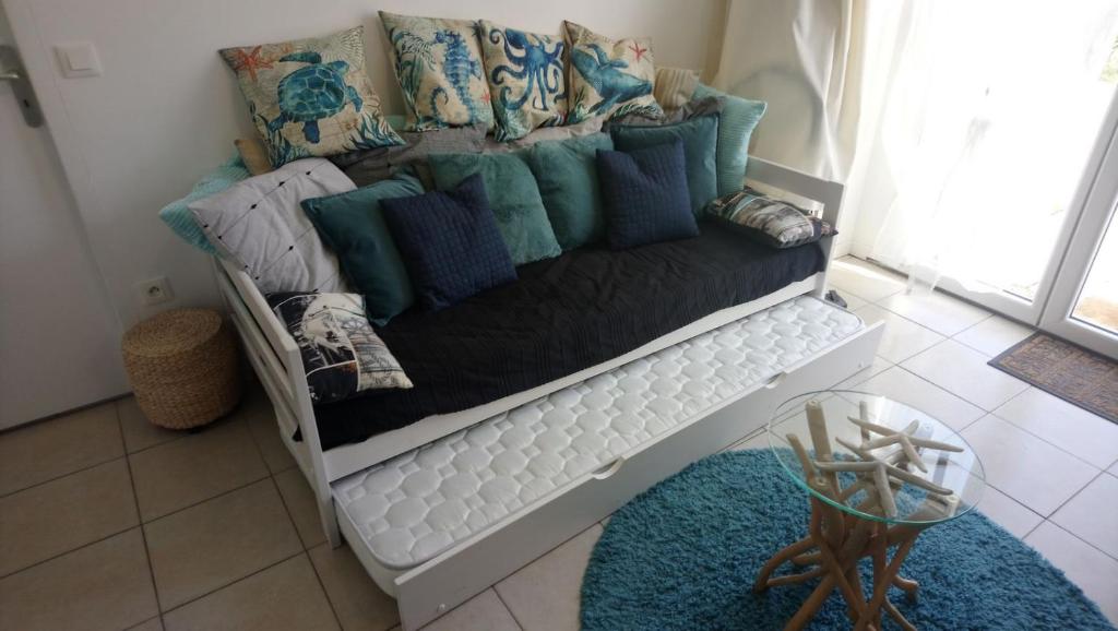 a couch with pillows on it in a room at Les Plénitudes du Rivage in Saint-Vincent-sur-Jard