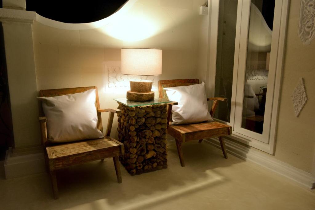two chairs and a table with a lamp in a room at Sal Secret Spot in Uluwatu