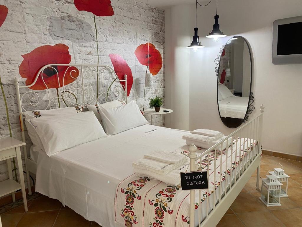 a bedroom with a white bed and a mirror at acquaesale rooms in Porto Cesareo