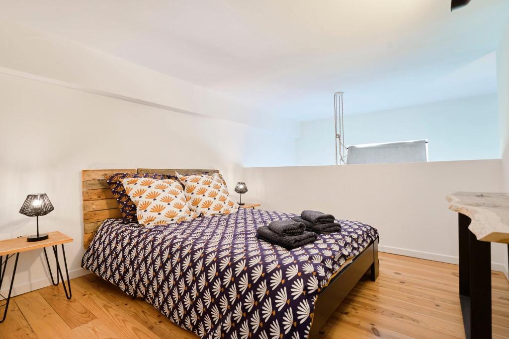 ein Schlafzimmer mit einem Bett und einem Tisch in einem Zimmer in der Unterkunft LocationsTourcoing - Le Loft two in Tourcoing
